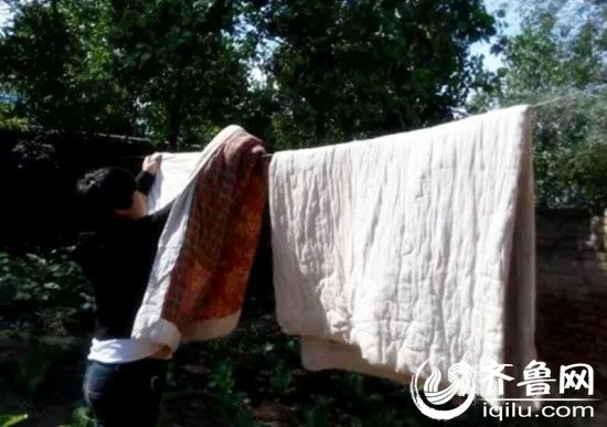 志愿者帮助老人翻晒棉被